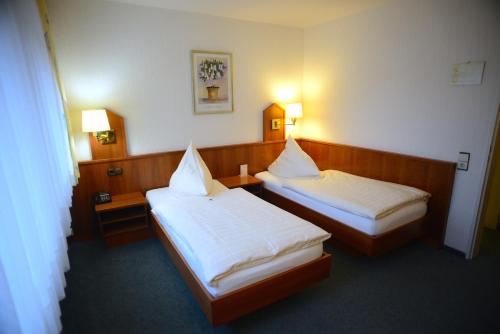 a hotel room with two beds and two lamps at Hotel Marienhof Düsseldorf Neuss in Neuss