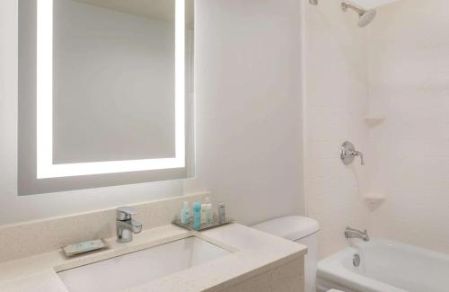 紐奧良的住宿－新奧爾良東溫德姆花園酒店，白色的浴室设有水槽和镜子