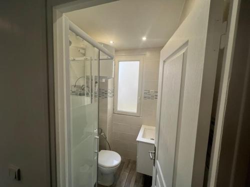 une salle de bain blanche avec des toilettes et un lavabo dans l'établissement Quiet & bright studio 15min away from Paris, à Bondy