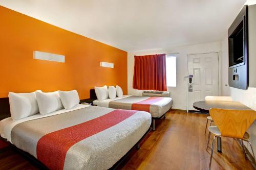 a hotel room with two beds and a table at Motel 6-Sunnyvale, CA - North in Sunnyvale