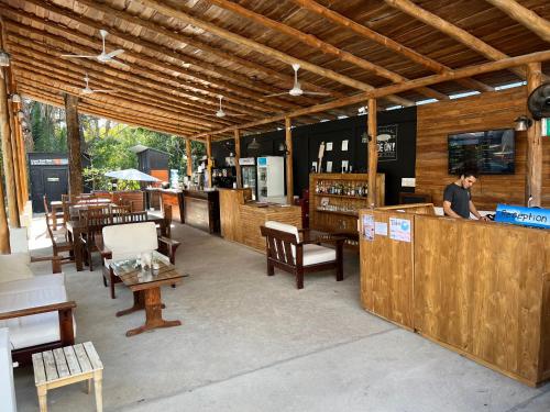 a man standing at the counter of a restaurant at Ride On! Surf Hotel in Nosara