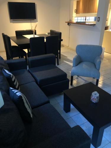 sala de estar con sofá, sillas y mesa en Alojamiento en San Rafael en San Rafael
