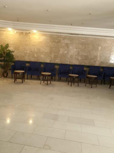 Burj Al Haram 2 Al Masarat في مكة المكرمة: غرفة بها طاولات وكراسي زرقاء