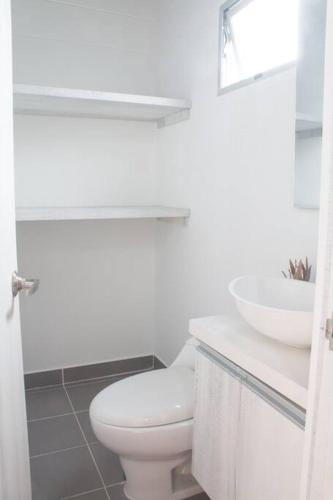 a white bathroom with a toilet and a sink at Espectacular apartamento Duplex VIP 501 con jacuzzy in Sabaneta
