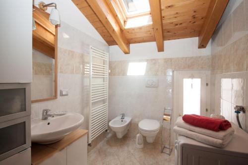 a bathroom with a sink and a toilet and a window at Casa del Sole - sleeps 4 with shared pool in Pianello Del Lario