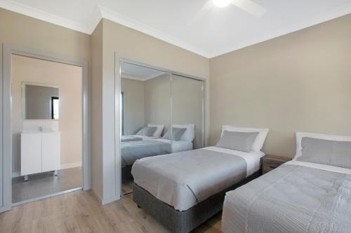 a bedroom with two beds and a mirror at Paxton paradise in Paxton