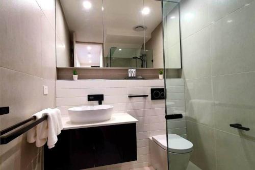 墨爾本的住宿－Flagstaff Hill West Melbourne，一间带水槽、卫生间和镜子的浴室
