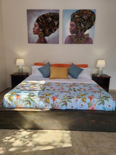 uma cama num quarto com duas fotografias na parede em Pool House with Shared Pool Access em David
