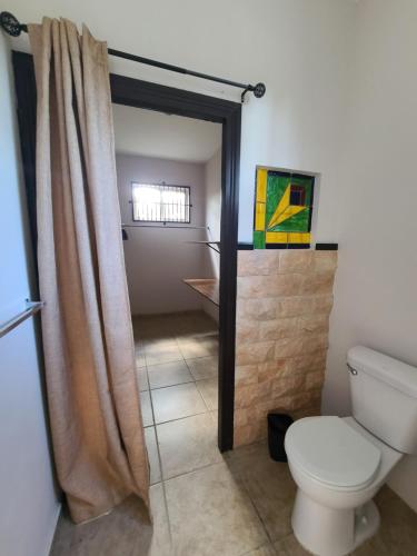 a bathroom with a toilet and a shower curtain at Pool House with Shared Pool Access in David
