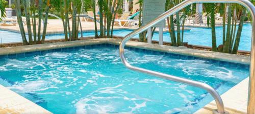 a swimming pool with a metal handrail in a swimming pool at Ocean View Penthouse in Palm-Eagle Beach