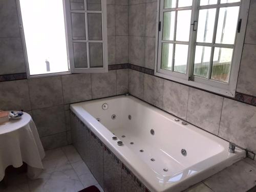 eine Badewanne im Bad mit 2 Fenstern in der Unterkunft Maximo confort en Salta in Salta