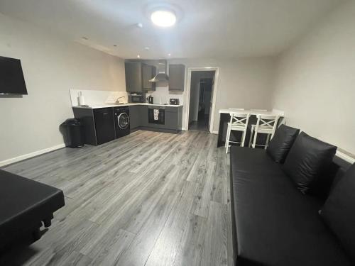 a living room with a couch and a kitchen at Hosted By Ryan - 2 Bedroom Apartment in Liverpool