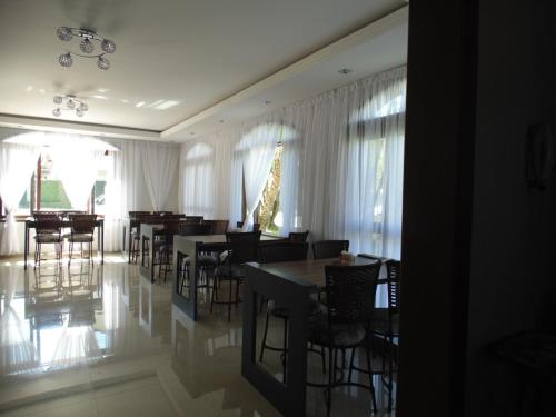 a dining room with tables and chairs and windows at Pousada Estrela Dalva in Penha