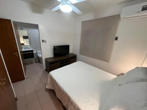1 dormitorio con 1 cama y TV de pantalla plana en Paz - Departamento en el centro de San Juan en San Juan