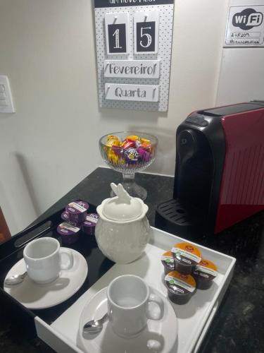 a kitchen counter with two tea cups and a microwave at Apartamento c/ piscina , Praia do Francês. in Marechal Deodoro
