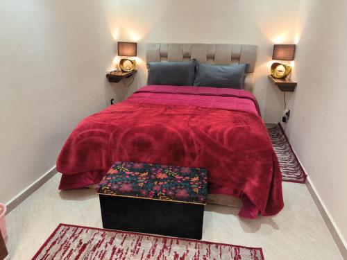 a bedroom with a large red bed with two rugs at magnifique appartement à rabat proche de la mer in Rabat