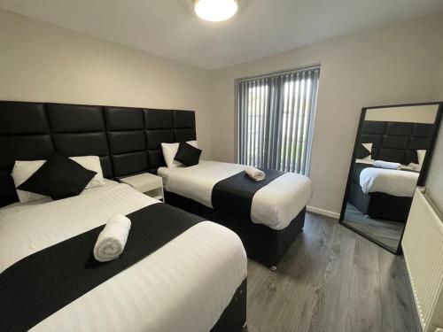 a hotel room with two beds and a mirror at Hosted By Ryan - 2 Bedroom Apartment in Liverpool