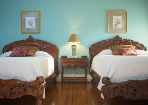two beds in a room with blue walls at Lookaway Inn in North Augusta