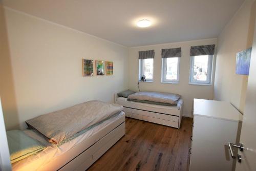 - une petite chambre avec 2 lits et un bureau dans l'établissement Meeresblick-Beachstart-Haus-2-WE-15, à Hohwacht