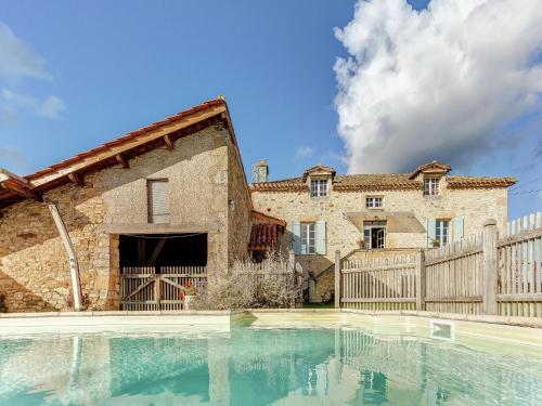 a house with a swimming pool in front of a building at Vintage Holiday Home in Loubejac with a Private Pool in Villefranche-du-Périgord