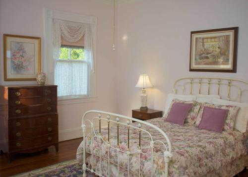 a bedroom with a bed and a dresser and a window at Lookaway Inn in North Augusta