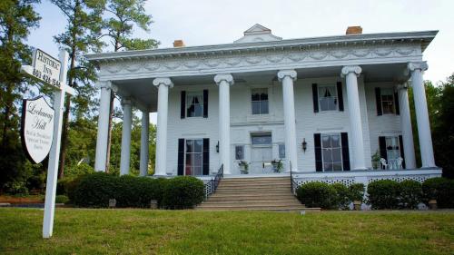 Biały dom z kolumnami i znakiem przed nim w obiekcie Lookaway Inn w mieście North Augusta