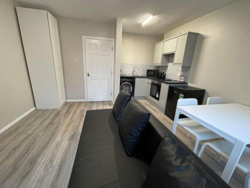 a living room with a couch and a kitchen at Hosted By Ryan - 1 Bedroom Apartment in Liverpool