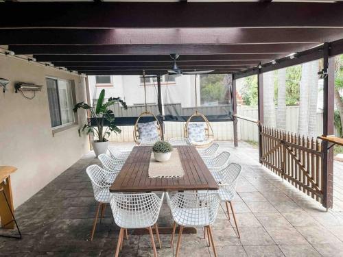 a wooden table and chairs on a patio at Seaside Serenity~GamesRoom~HotSpa! in Port Macquarie