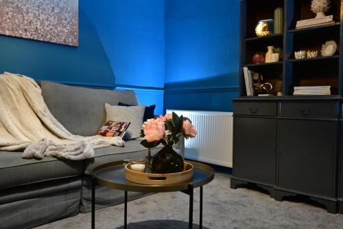 a living room with a couch and a table with flowers at Luxury accommodation in Durham centre in Durham