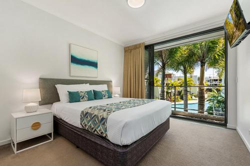 a bedroom with a large bed and a large window at Sand Dunes Resort Accommodation in Marcoola