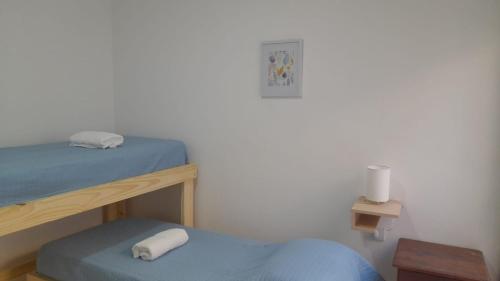 a bedroom with two bunk beds and a blue ottoman at DEPARTAMENTO URBANO EL CHALLAO in Mendoza