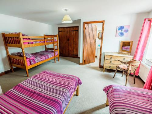 a bedroom with two bunk beds and a desk at Pine Cottage - Rchp140 in Calton