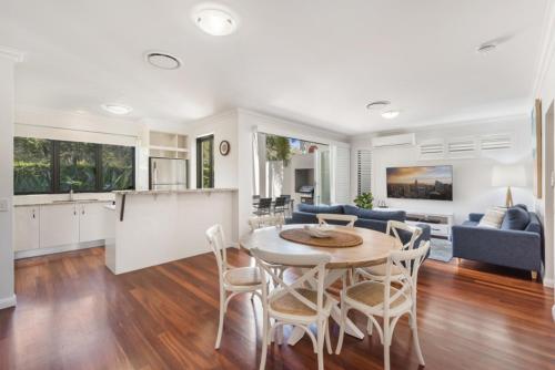 a kitchen and living room with a table and chairs at Sand Dunes Resort Accommodation in Marcoola