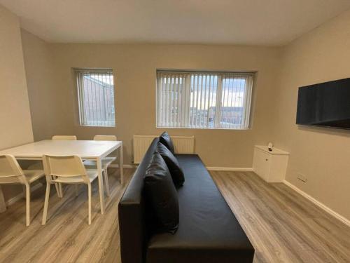 a living room with a black couch and a table at Hosted By Ryan - 1 Bedroom Apartment in Liverpool