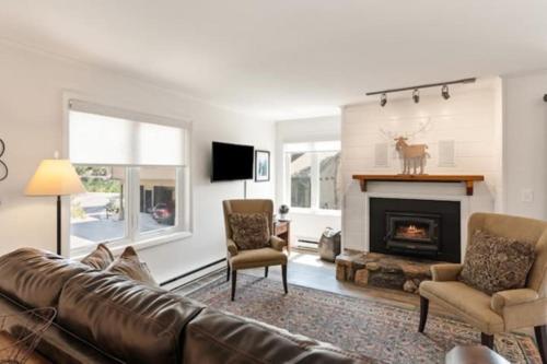 a living room with a couch and a fireplace at Mountainside Cozy Walk to Gondola Hot Tub Condo in Steamboat Springs