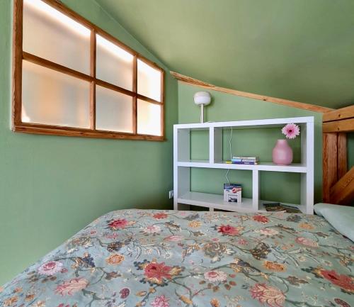 a bedroom with a bed and a white shelf at Mini Loft close to Logar Valley in Rečica ob Savinji