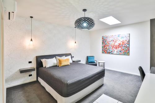 ein Schlafzimmer mit einem Bett und einem Wandgemälde in der Unterkunft Indulge Apartments - CBD in Mildura