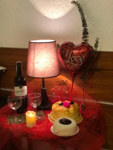 a table with a cake and a lamp and a heart at Casa Generosa in Baguio