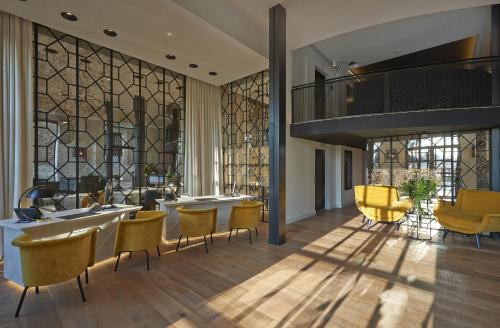 a lobby with yellow chairs and a staircase at Serras Barcelona in Barcelona