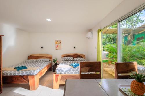 a room with two beds and a table and chairs at Hotel Boutique D Angelo in Manzanillo