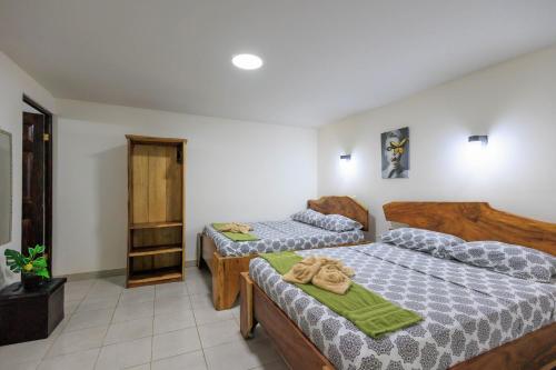 a bedroom with two beds and a cabinet at Hotel Boutique D Angelo in Manzanillo