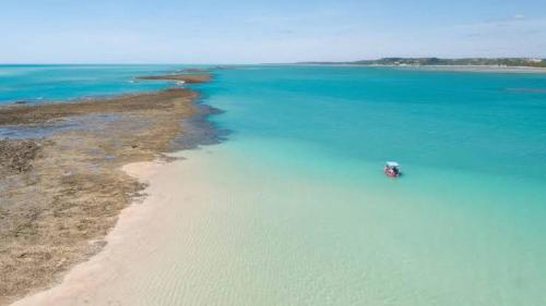 un barco en el agua junto a una playa en Pousada LuMar Maragogi, en Maragogi