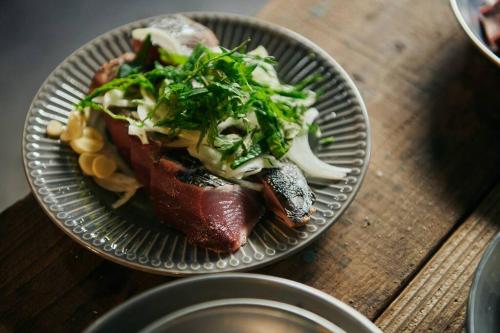 a plate of food with meat and vegetables on a table at 目の前が吉野川・雨天でも屋外体験ができる絶景の一軒家 in Ōtakuchi