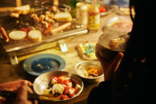 a person holding a bowl of food on a table at 目の前が吉野川・雨天でも屋外体験ができる絶景の一軒家 in Ōtakuchi