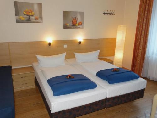 a bedroom with a bed with blue pillows on it at Hotel Sonne - Haus 2 in Idstein