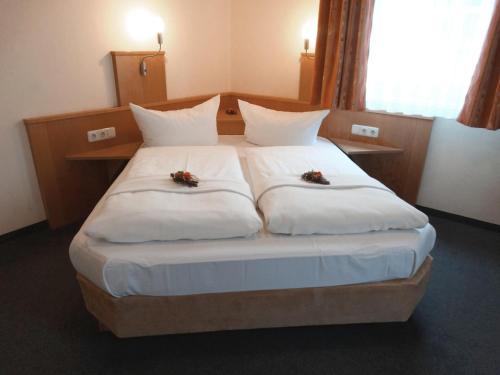 a bedroom with a large white bed with flowers on it at Hotel Sonne - Haus 2 in Idstein