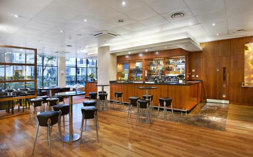 a bar in a restaurant with chairs and tables at Central Park Hotel in London