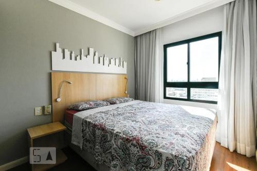 una camera con un letto e una grande finestra di Flat 4 Estrelas Pinheiros a San Paolo