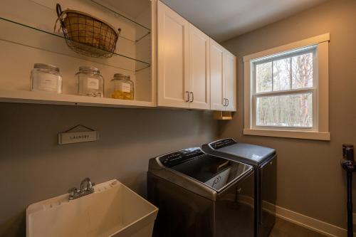 a kitchen with a washer and dryer in a room at Lake Effect Lodge 3 Minutes From The Beach! in Holland