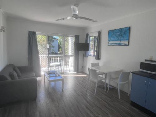 a living room with a couch and a table and a dining room at Cocos Holiday Apartments in Trinity Beach